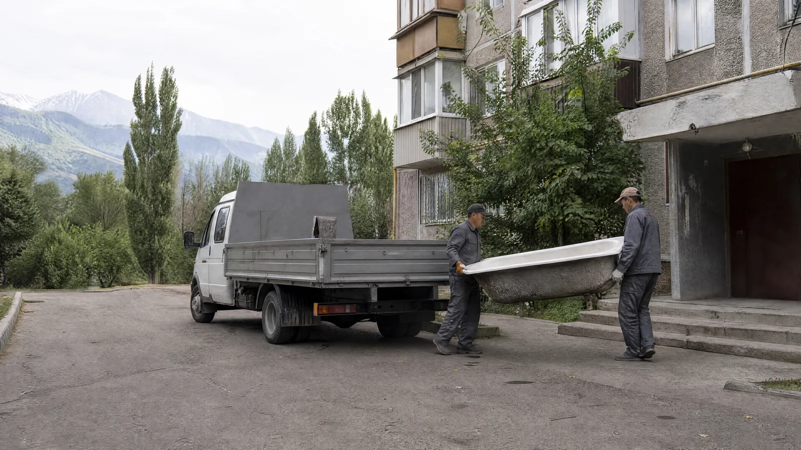 Грузчики TRASHOFF выносят чугунную ванну из подъезда к газели