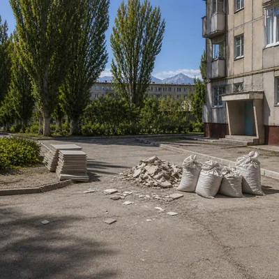 Двор у подъезда: штабеля мешков с бетонным боем и старой плиткой