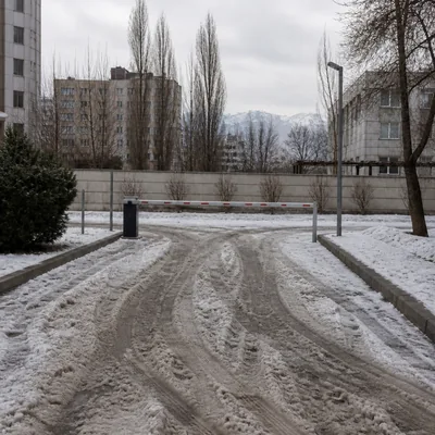 Снежная каша и колёсные колеи на въезде в паркинг