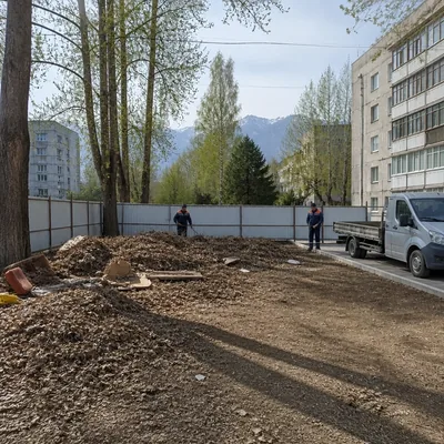 Двор частного дома в Медеуском: кучи листвы и старых вещей у забора