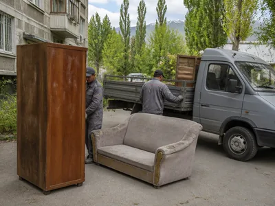 Старый шкаф и диван во дворе перед погрузкой