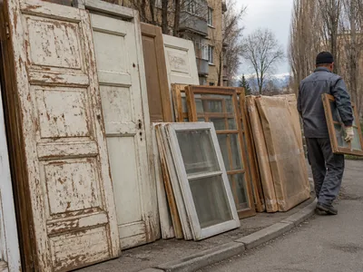 Старые деревянные двери и оконные рамы перед вывозом