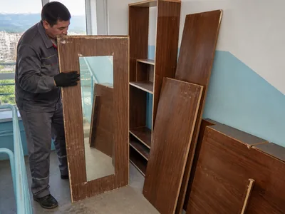 An old wall unit with top cabinets before removal from an Almaty apartment
