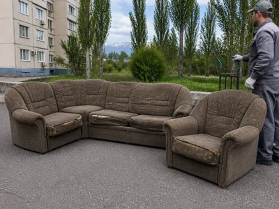 An old corner sofa and armchair ready for removal
