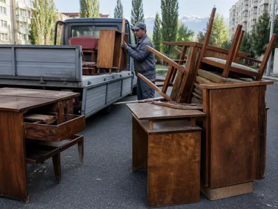 Old office desks and chairs, stacked for loading